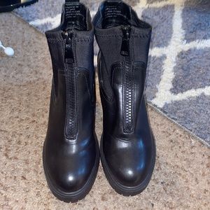 Black high top boots with a zipper on the front
